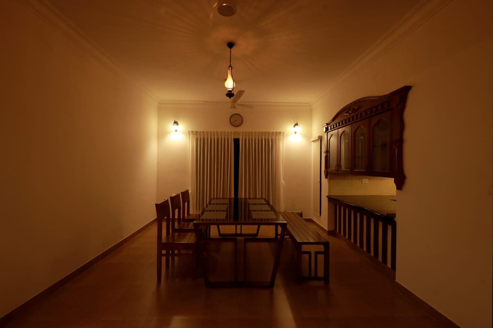 The dining table laid beneath a hanging lantern
