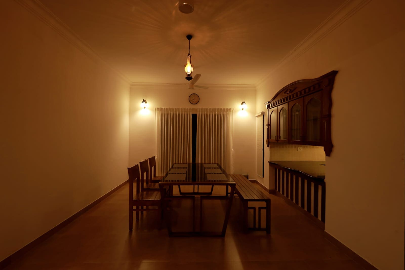 Long timber dining table beneath a hanging lantern