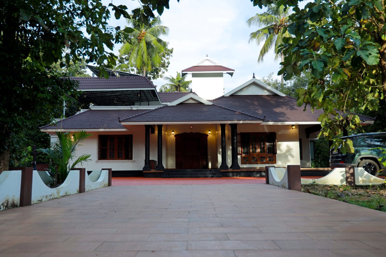 The tiled roof and palms in late afternoon light