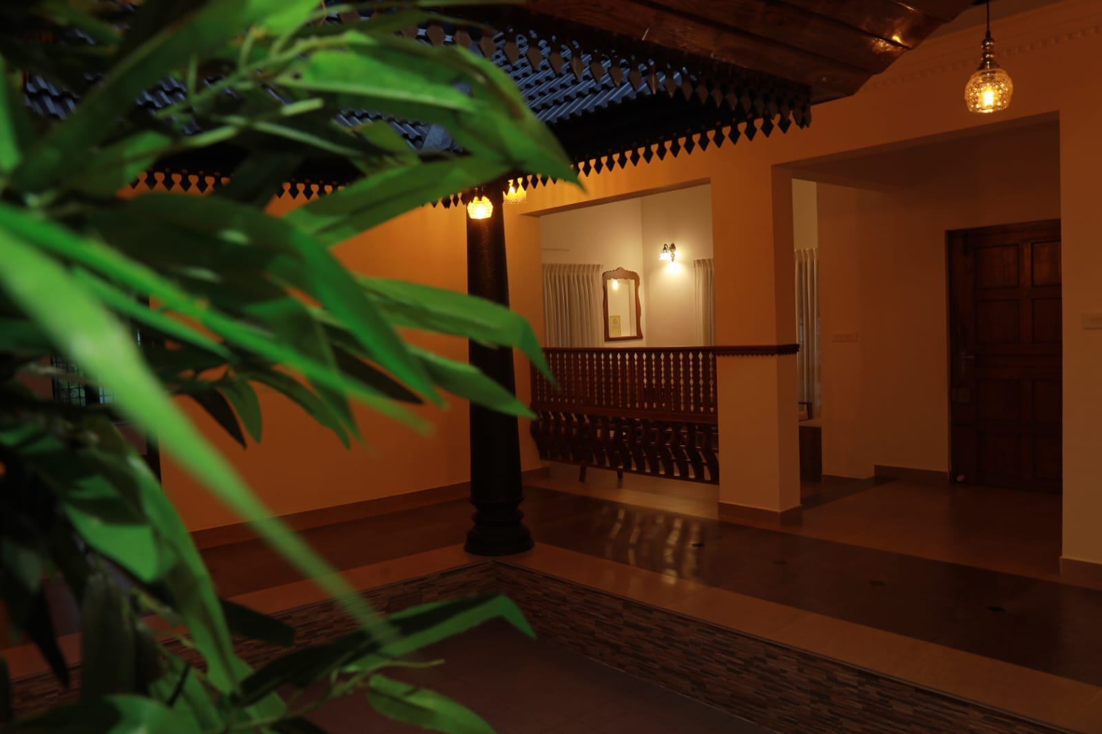 Bamboo leaves framing the lamp-lit inner courtyard verandah